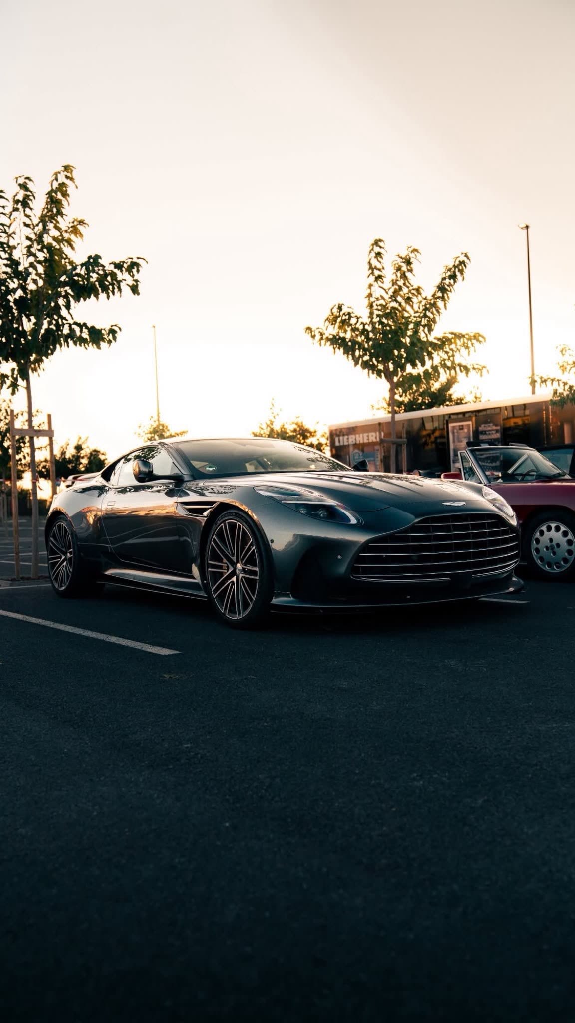 Aston Martin DB12 im Gegenlicht der untergehenden Sonne