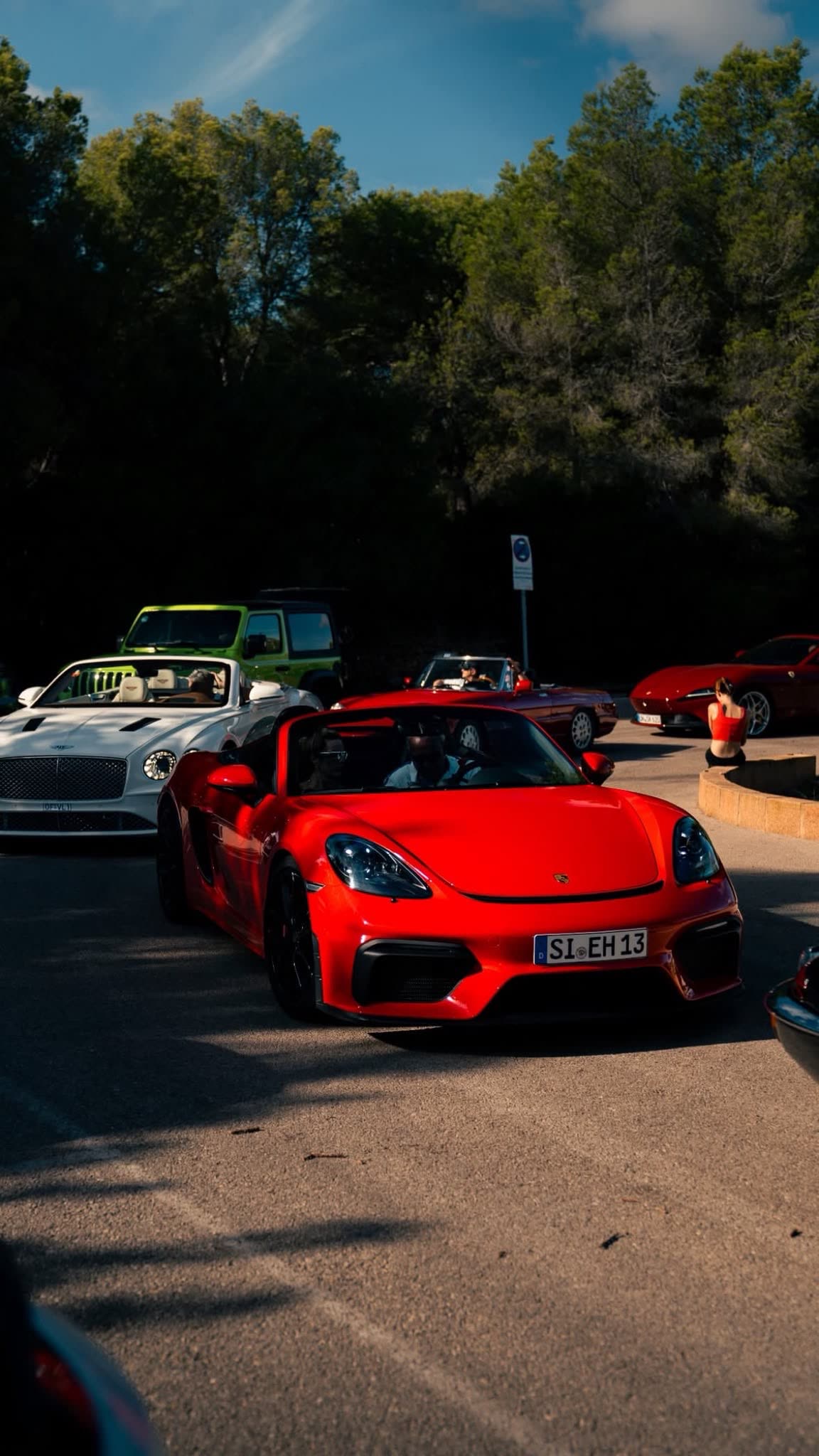 Roter Porsche 718 Spyder mit Teilnehmern bei Tageslicht